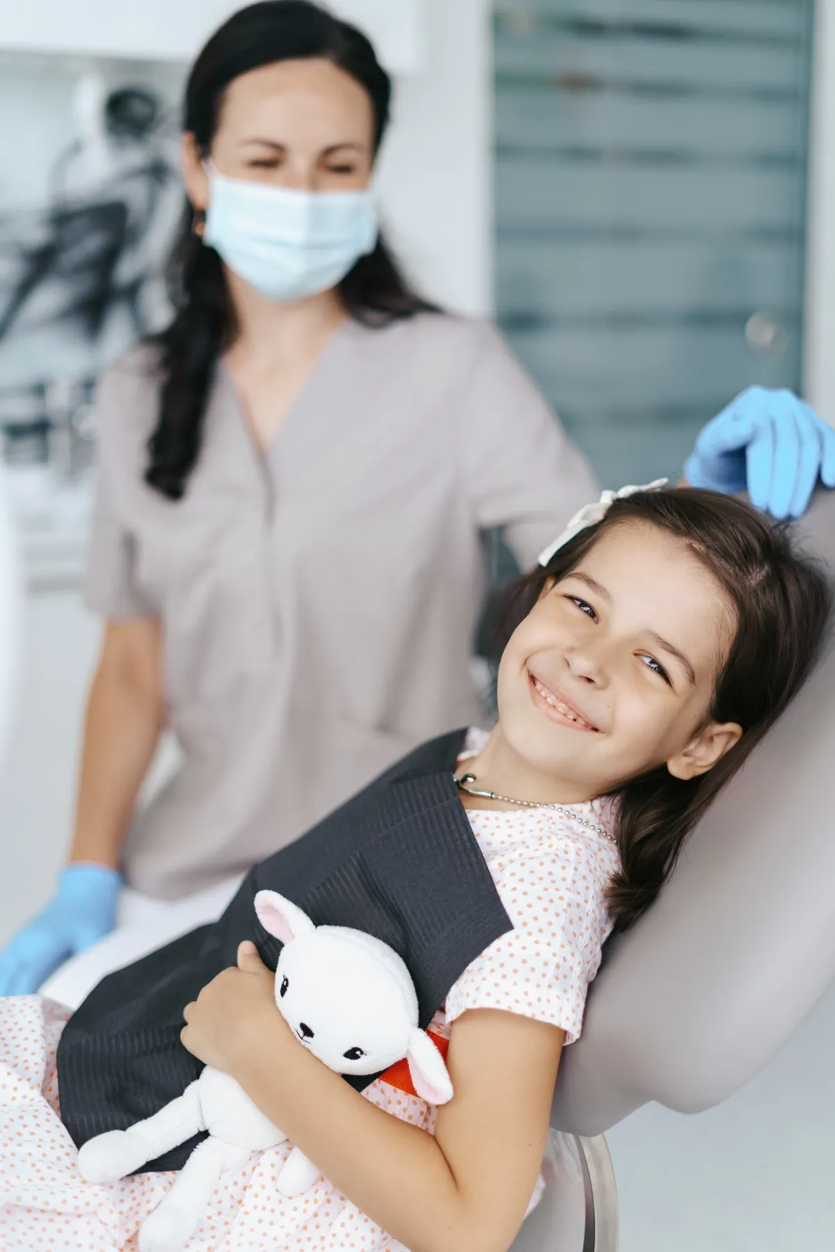 Niña sonriendo en el sillón dental durante su control de ortodoncia